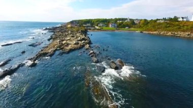 Kıyı şeridinin üzerinde kayalık bir tavanın videosu. Dalgalar su altında kayalık katmanlar gösteriyor.