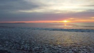 Maine 'de okyanus manzaralı büyülü bir gündoğumuna çarpan dalgaların videosu.