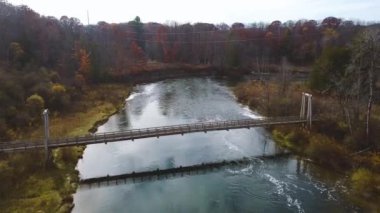 Michigan 'da nehrin üzerindeki süspansiyon köprüsünün sonbahar titreşimli videosu.