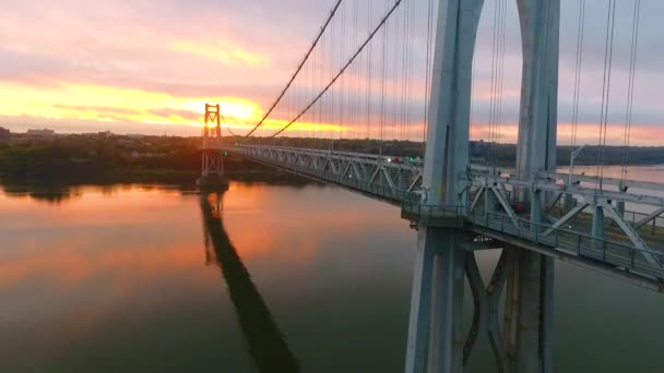 ハドソン川の美しいアメリカの橋の背後にあるピンクと金色の日の出の光で空中低から高のビデオ — ストック動画