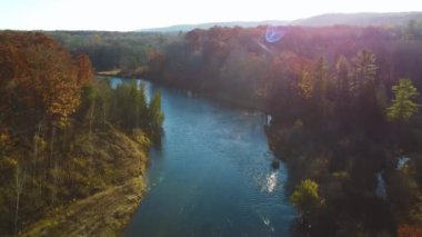 Hava ve güneş patlamalarının videosu Michigan nehri ve ormanı insansız hava aracından düşüyor.