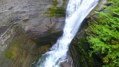 Arka planda taş kemer köprüsü olan büyük şelaleden kanyona kadar uzanan Aerial videosu.