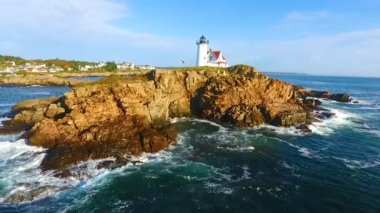 Maine kıyısındaki Nubble Deniz feneri adasında okyanus dalgalarıyla dolu bir havadan çekim videosu.