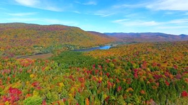 Renkli sonbahar ormanlarının ve dağların küçük göle doğru gittiği New York manzarasının videosu.