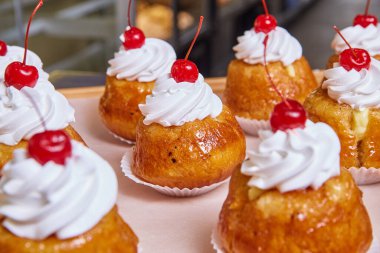 Çırpılmış krema üzerine ananaslı kek vişneli pasta resmi.