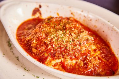 Lazanya resmi öğle yemeği özel yemek İtalyan kırmızı makarna sosu maydanozlu beyaz tabak.