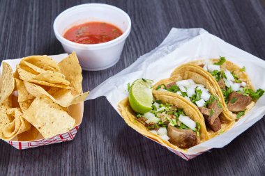 Kırmızı salsa soslu taco yemeği 3 mısır tortilla lengua inek dili Meksika limonu dilimi