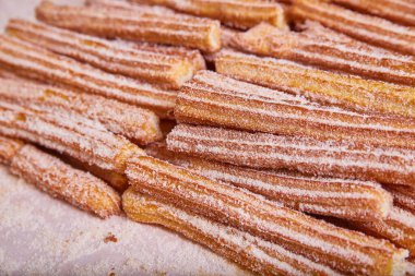 Bir tepsi churros görüntüsü yıldız şeklinde Meksika usulü tarçın şekerli hamur işi.