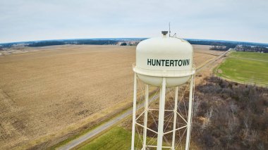 Bomboş arazi insansız hava aracı görüntüsü, kışın kısmi orman ve Orta Batı Amerika 'da Huntertown şehir su kulesi olan yeşil çimenler.