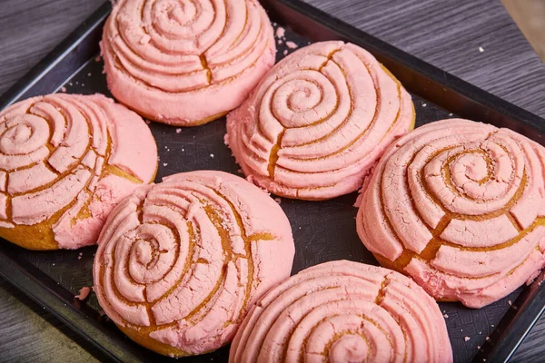 粉红草莓糕点烘焙好的墨西哥甜面包锥形贝壳糖霜花纹图像 — 图库照片
