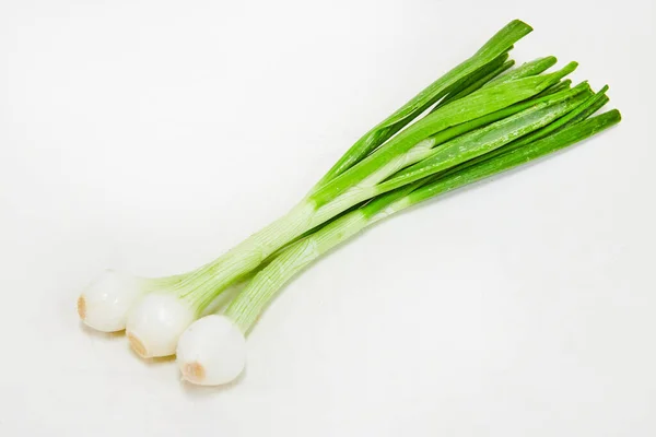 Beyaz arkaplanda üç taze soğan resmi