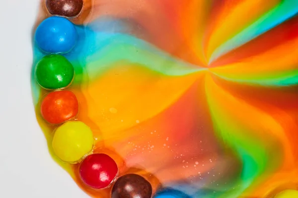 Image of Star burst of color from candy with tie dye center and skittles on outer ring on white background