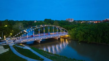 Image of MLK bridge at dusk with night lights leading into Headwaters Park aerial clipart