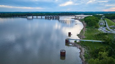 Mavi ve pembe bulutlu gün batımının yeşil kıyı şeridi antenli Ohio Nehri üzerindeki görüntüsü