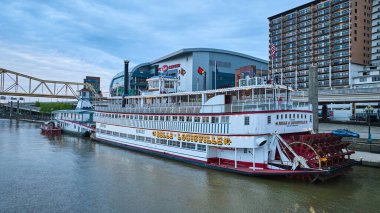 Image of Aerial over Ohio River water red steamboat paddlewheel next to city Belle Louisville clipart