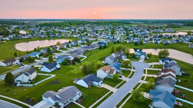 Banliyö evleri üzerinde gün batımının görüntüsü. Dört gölet Cul-de-sac yeşil çimenli.