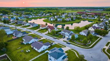Şehir dışındaki evlerin yarımadadaki gölcüklerinin görüntüsü. Komşu evleri, günbatımı antenleri.