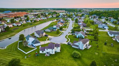 Yerel okul yakınlarındaki banliyö gölünün kenarındaki Cul-de-sac üzerinde pembe günbatımı görüntüsü