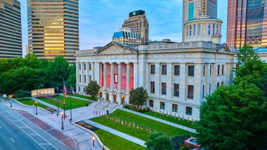 Capital Square Foundation Columbus Ohio 'nun görüntüsü. Gün doğumunda yeşil çimlerde bayrakları var.