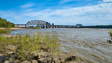 Ohio Nehri üzerindeki uzak köprünün görüntüsü Louisville KY kireçtaşı kıyısı, suya bakan ağaçlar.
