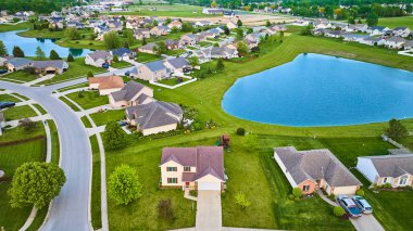 Banliyö evleri arasındaki iki gölet görüntüsü yeşil gübrelenmiş çimenler