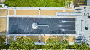 Tokmaklı uzun çeşme havuzu ve aşağı doğru üç jetin görüntüsü.