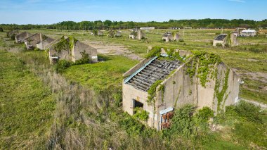 Yeşil sarmaşıkların aynı terk edilmiş binalarda sürünmesi doğa tarafından ele geçirilmiş çimento yapıları.