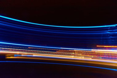 Geceleri mavi, sarı ve turuncu neon ışıkların yatay kıvrımlı çizgileri.