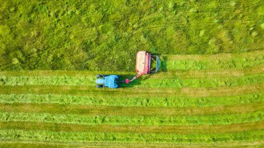 Tarladaki otları biçen traktörün hava aracı görüntüsü