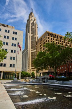 Çeşmenin dibinde Amerikan ve Ohio bayrakları ve arka planda LeVeque Kulesi olan taştan kelimeler.