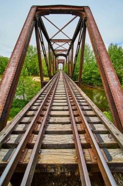 Demir kiriş demiryolu köprüsü üzerinde Kokosing Nehri üzerinde yürüyen Uzak Kişinin görüntüsü