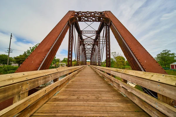 Image of Wooden walking bridge cutting through rusty iron train bridge in Mount Vernon Ohio