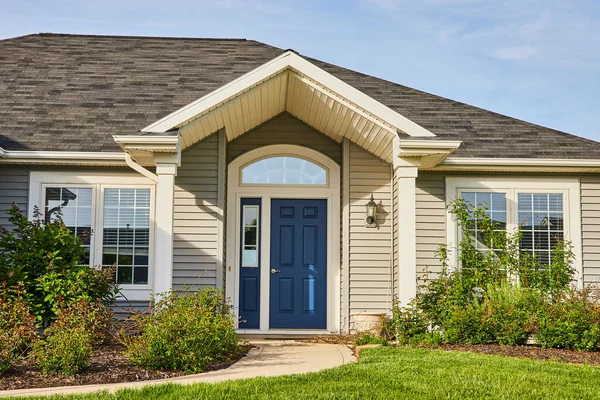 Gri kaplama ev mavi ön kapı, kemer girişi, kayrak gri kareli çatı peyzajı