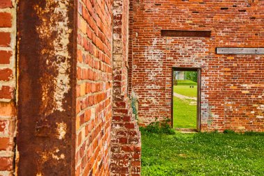 Fabrikanın içindeki çimenlik alana ve kaldırıma açılan kapı aralığının görüntüsü