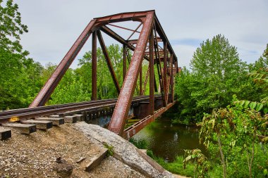 Rusty Demir Demiryolu Köprüsü 'nün resmi Ohio Yolu' nun kalbi Kokosing Nehri 'nin altından akıyor.