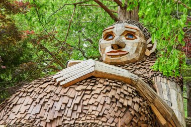 Dost canlısı orman devi Mama Loumari 'nin resmi. Yazın ağaca yaslanırken, bebek karnında bir yumru.