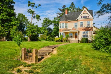 Yolun sonundaki kapı ve eve bağlı kısmi kule sarmalı Eski kır evi görüntüsü