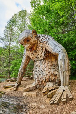 Odun devi Küçük Nis 'in yemyeşil orman arka planıyla kıyıya bakan dikey görüntüsü.