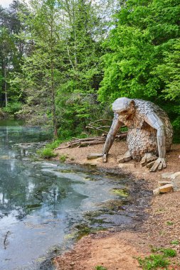 Küçük Nis 'in kıyıdaki yemyeşil ormanın önündeki kirli kıyı sularına bakarken dikey görüntüsü.