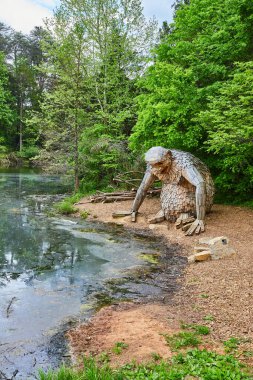 Sahildeki küçük Nis 'in yemyeşil ormanın önündeki kirli göl suyuna bakışı.
