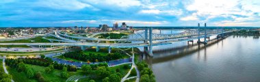 Panorama 'nın gün batımı görüntüsü. Altın saat süspansiyon köprüleri Louisville' in parlayan gece ışıkları.