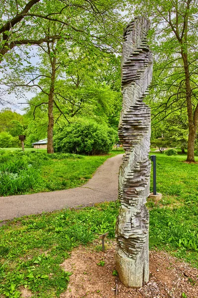 Image of Spiral Double Helix art crafted by artist Heike Endermann standing next to park trail in summer
