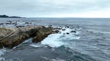Havadan düşen dalgaların videosu çoğunlukla batık kayalık kıyı şeridi ve Pasifik Okyanusuna çarpıyor.