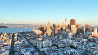 San Francisco 'nun şehir merkezindeki gökdelenlerin arkasında San Francisco Körfezi Köprüsü' nün videosu.