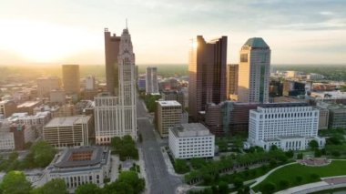Gündoğumunun geniş açılı videosu Columbus OH gökdelenlerine vuruyor. Nehrin yukarısından hava görüntüleri.