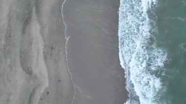 Kumlu sahil havası dikey açısında köpüğe dönüşen dalgaların aşağı bakan görüntüsü
