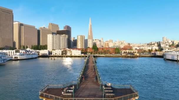明るく印象的なピア7と遠くのサンフランシスコの高層ビルのゴールデンアワーのビデオ — ストック動画