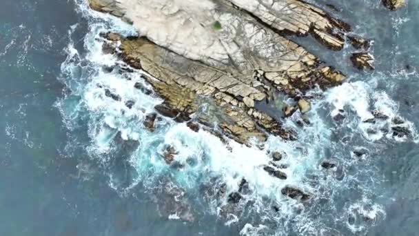 海底岩に衝撃を与える白い紋章波の下方スパイラル空中ビデオと崩壊する海岸線 — ストック動画