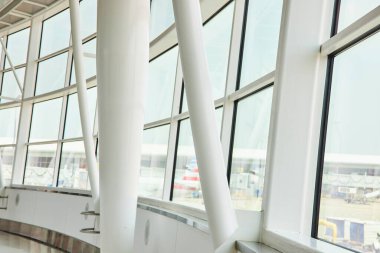 Havalimanının dış yüzeyine bakan kalın beyaz kirişli eğimli pencerelerin iç görüntüsü