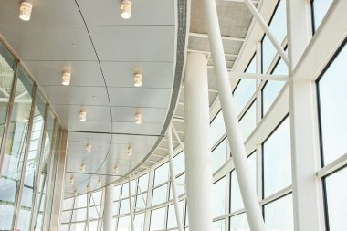 Beyaz tavan mimarisi ve gökyüzüne açılan pencereli sütunların soyut görüntüsü